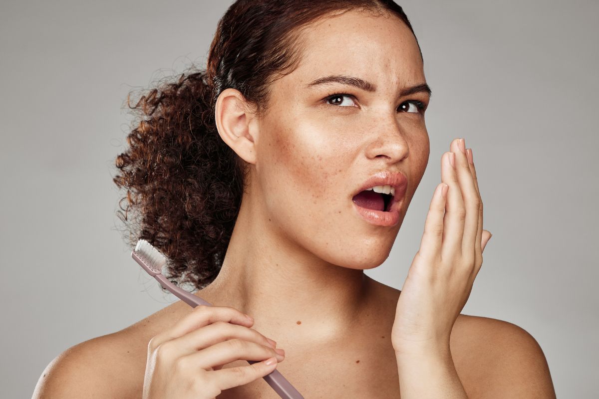 The woman checks if she still has smoke breath.