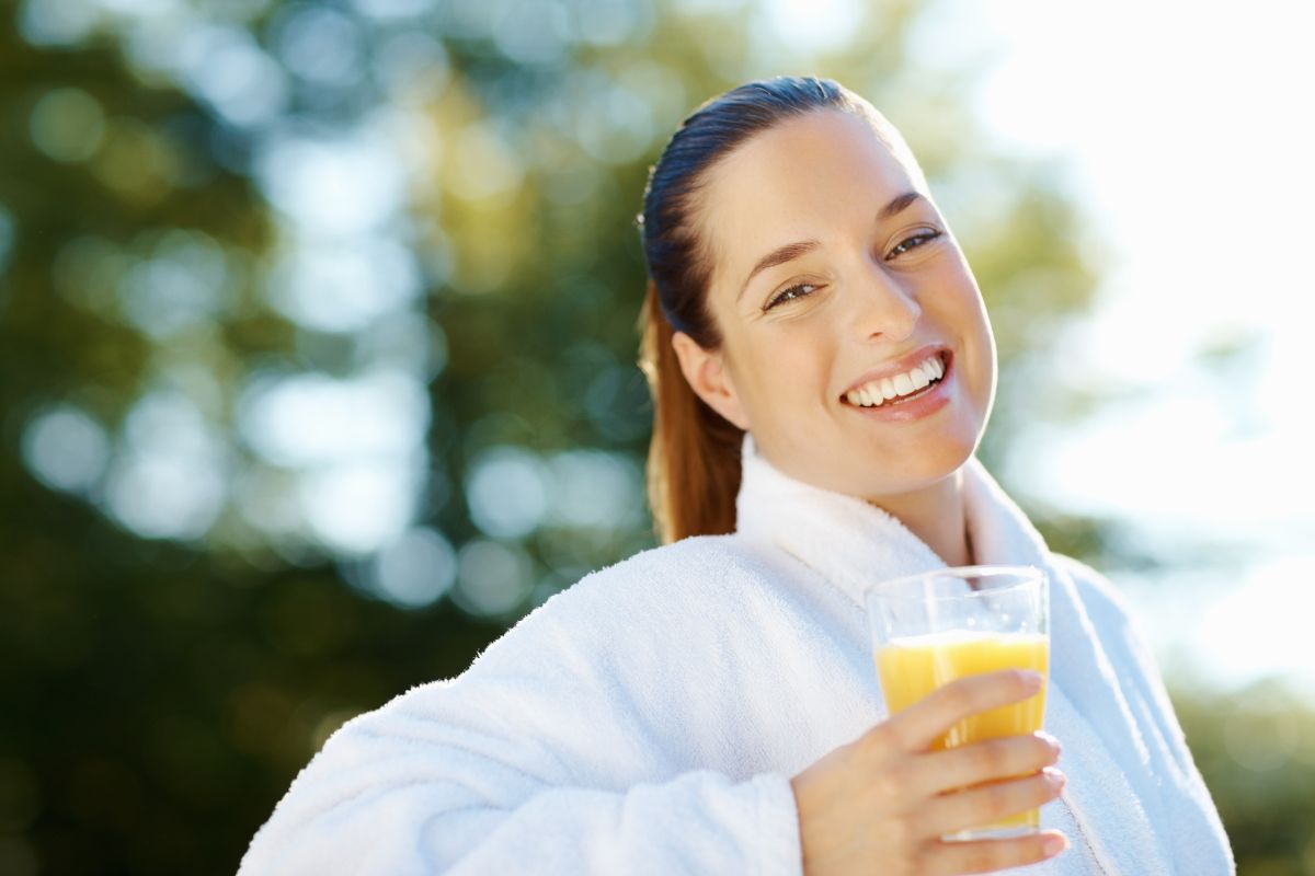 A woman holding a drink full of probiotic strains for women health