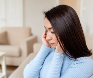 The woman is experiencing silent sinus syndrome.