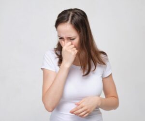 The woman is experiencing nasal obstruction.