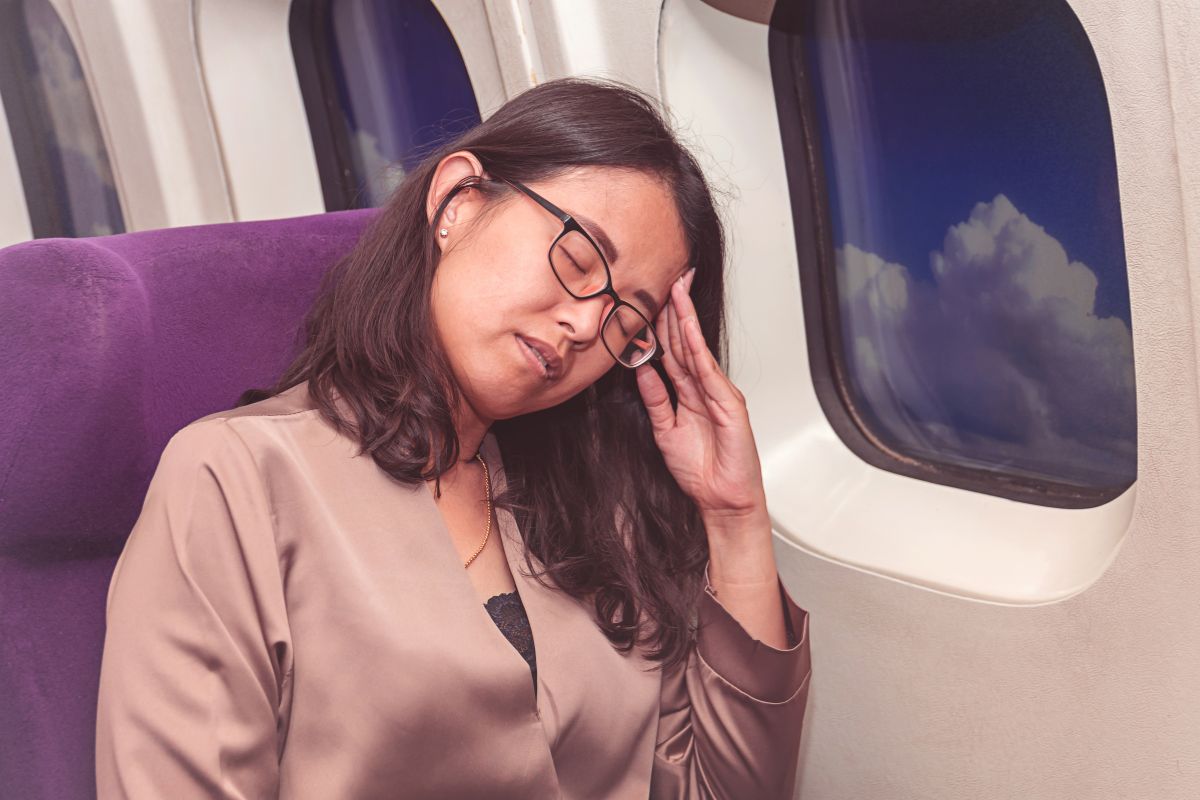 The woman is not comfortable sitting on the plane.