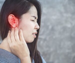 The woman's ear hurt when she chewed.