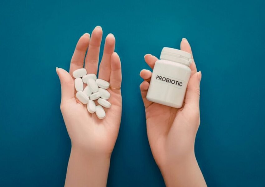 A person is holding a bottle of a probiotic supplement.