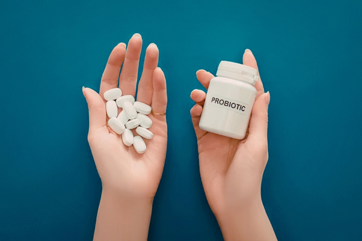 A person is holding a bottle of a probiotic supplement.