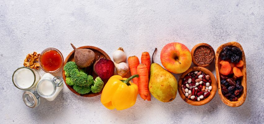 Flat lay of probiotic fruits, vegetables, dairy, and fiber-rich foods supporting digestive wellness.