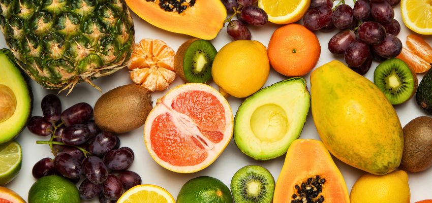 Vibrant collection of probiotic fruits including pineapple, papaya, kiwi, avocado, citrus, and grapes.