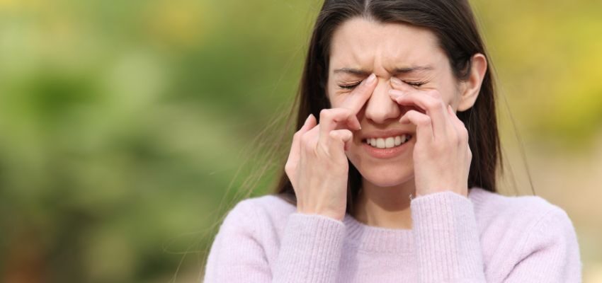 The woman feels a dry nose due to dehydration.