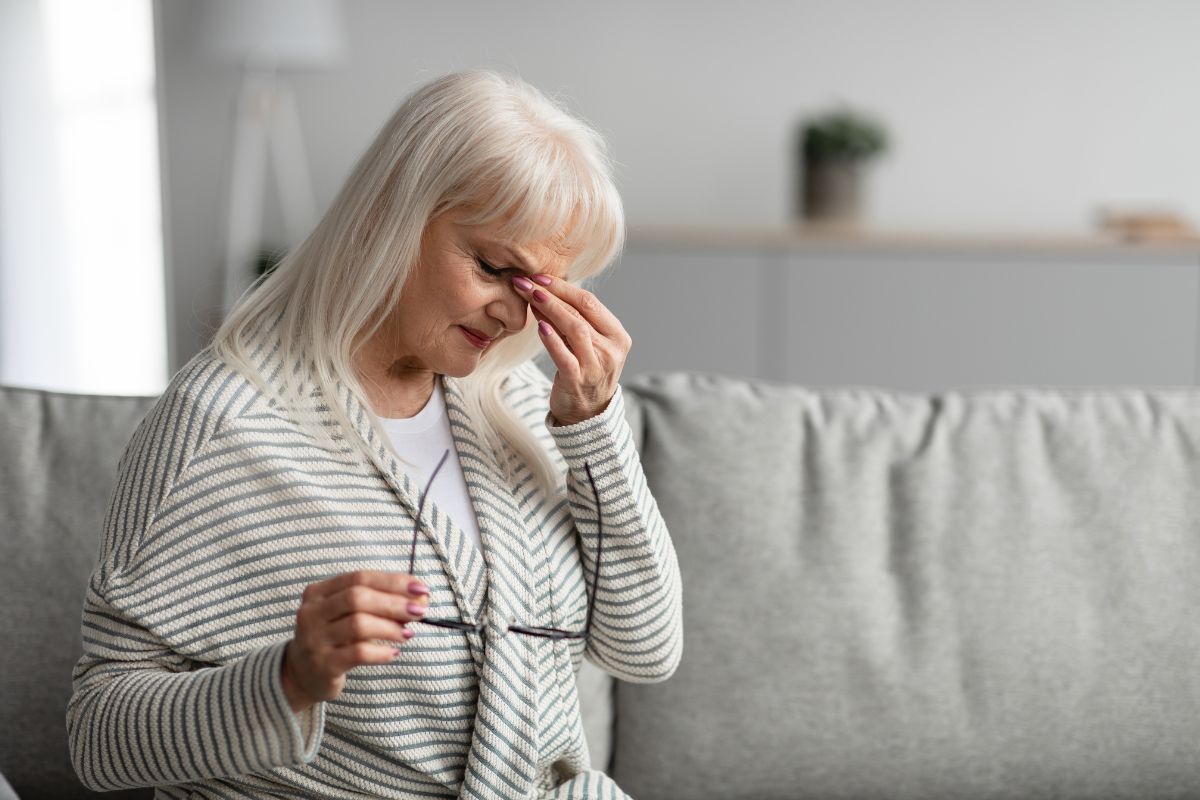 The aged woman feels a dry nose.