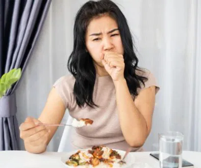 The awkward experience of a woman coughing after eating at a restaurant.