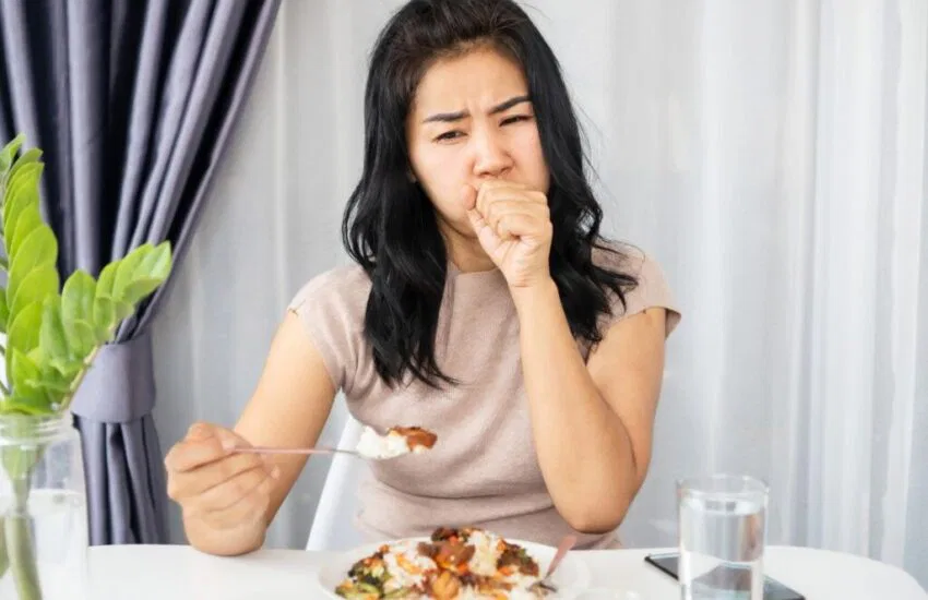 The awkward experience of a woman coughing after eating at a restaurant.