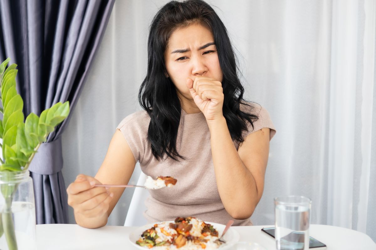 The awkward experience of a woman coughing after eating at a restaurant.