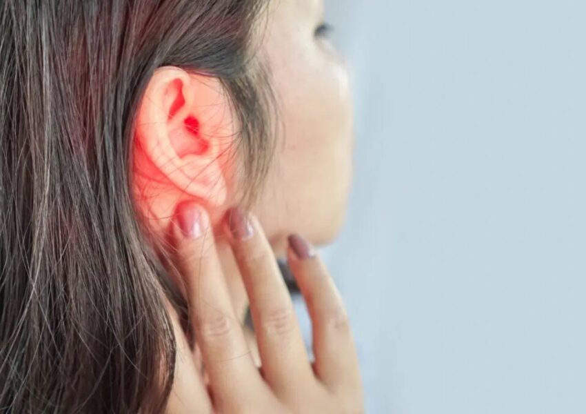 can-a earache-cause-a-headache A woman has a fever and experiences an earache and headache simultaneously.