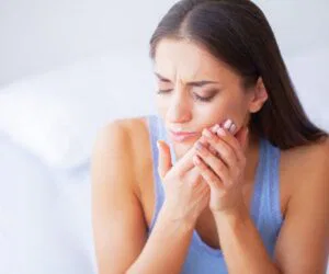 The woman feels discomfort due to mouth ulcers.