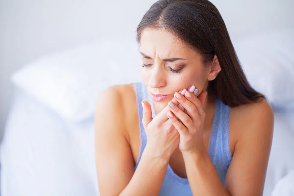 The woman feels discomfort due to mouth ulcers.