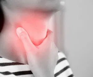 The woman has a sore throat.