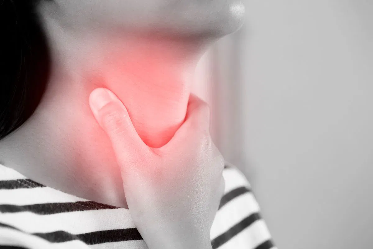 The woman has a sore throat.