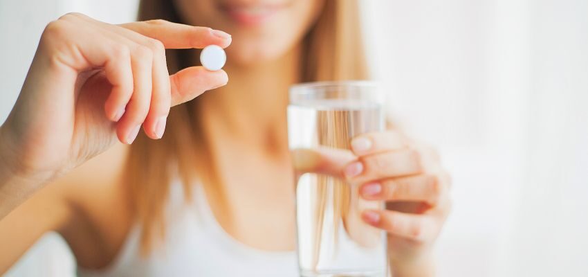 The woman is taking probiotic supplements.