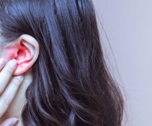 The woman feels pain in her ear every time she swallows.