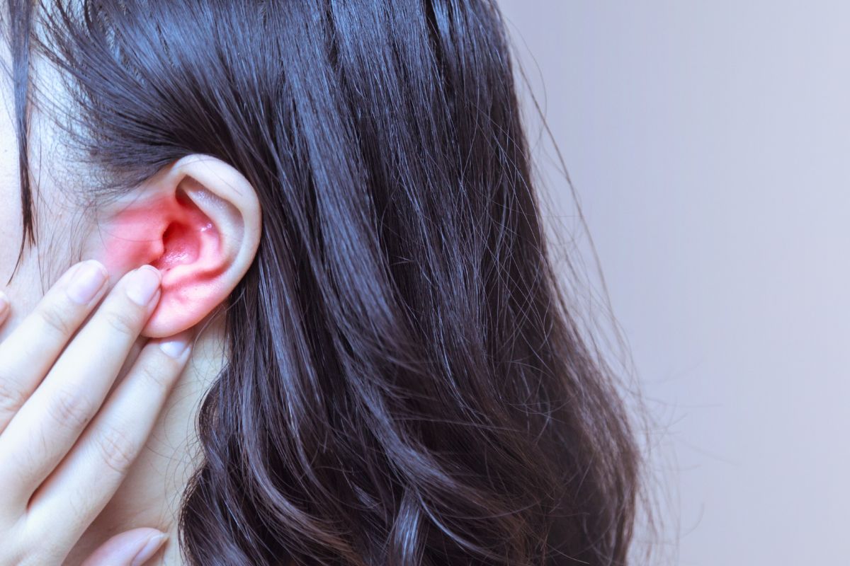 The woman feels pain in her ear every time she swallows.