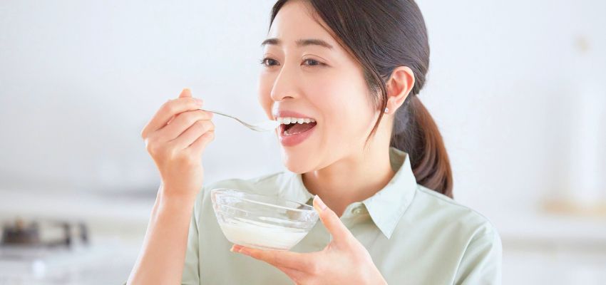 The woman eats yogurt to relieve acid reflux.