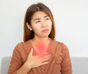 The woman is experiencing acid reflux.