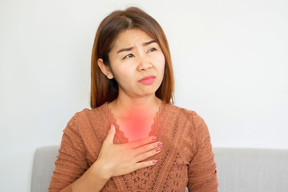 The woman is experiencing acid reflux.