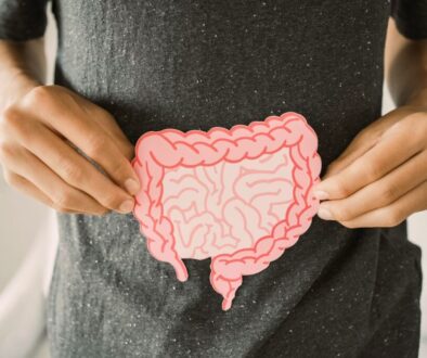 Person holding a paper model of the human intestines highlighting the effects of worst foods for gut health