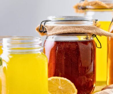 Is kombucha good for gut health shown with homemade kombucha jars, bright yellow lemonade, and fresh lemon