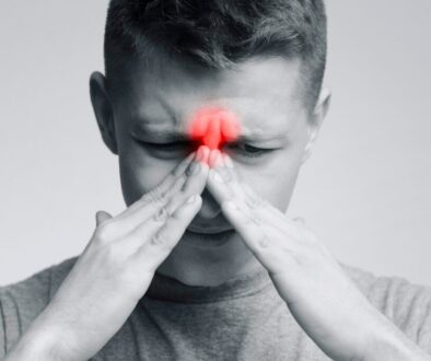 Man pressing his face in sinus pain, highlighting the need for foods that clear sinus congestion.