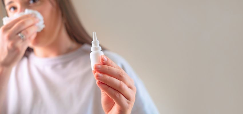Woman using nasal spray as an effective option for sinus pain relief.